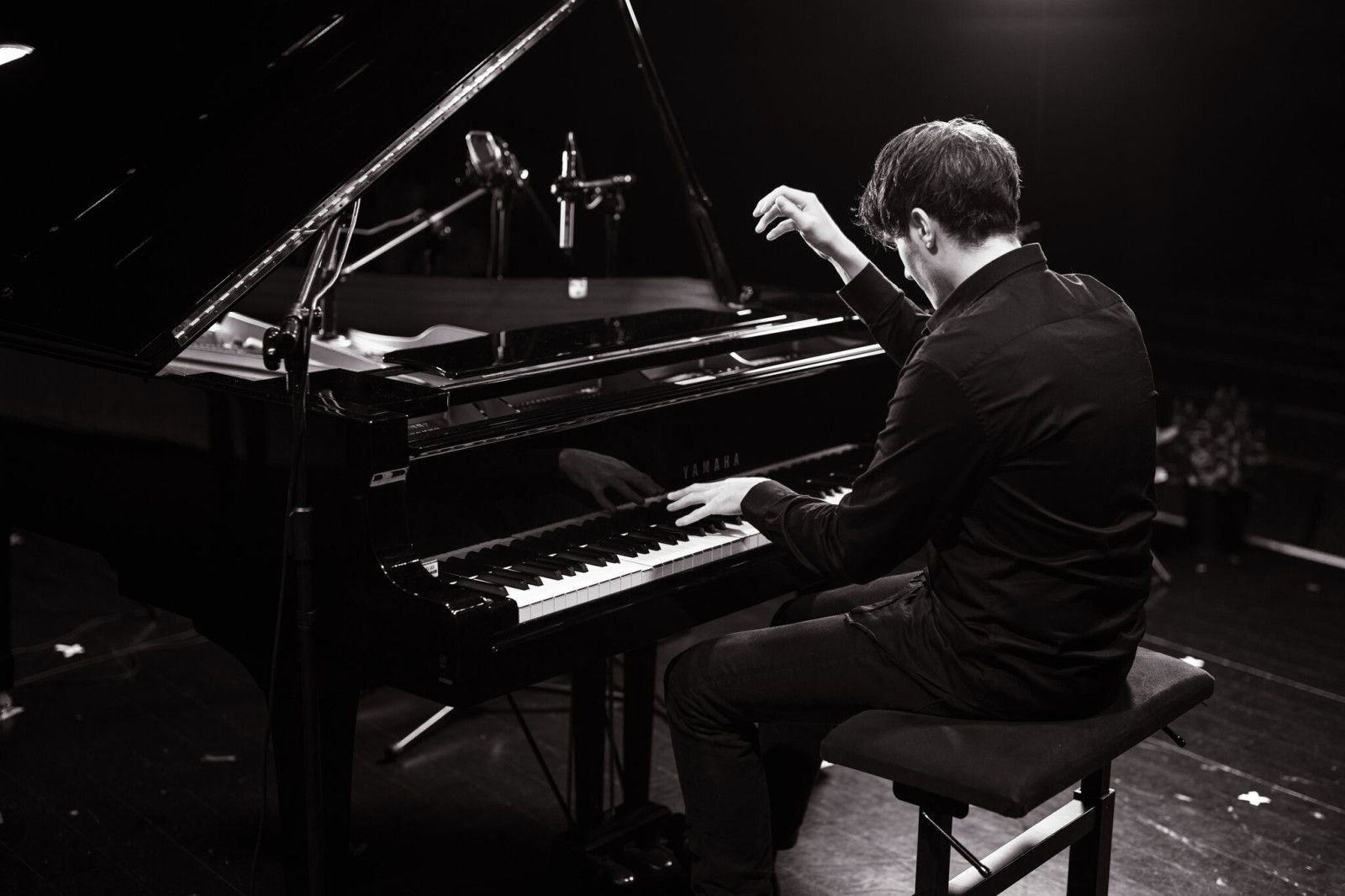 Pianista siedzący przy fortepianie, widok z tyłu